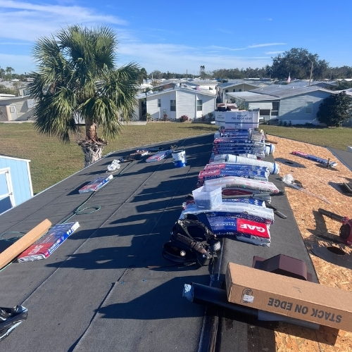 Roof replacement supplies on a Anna Maria, FL home, showing stacked shingles, nails, and materials ready for installation.